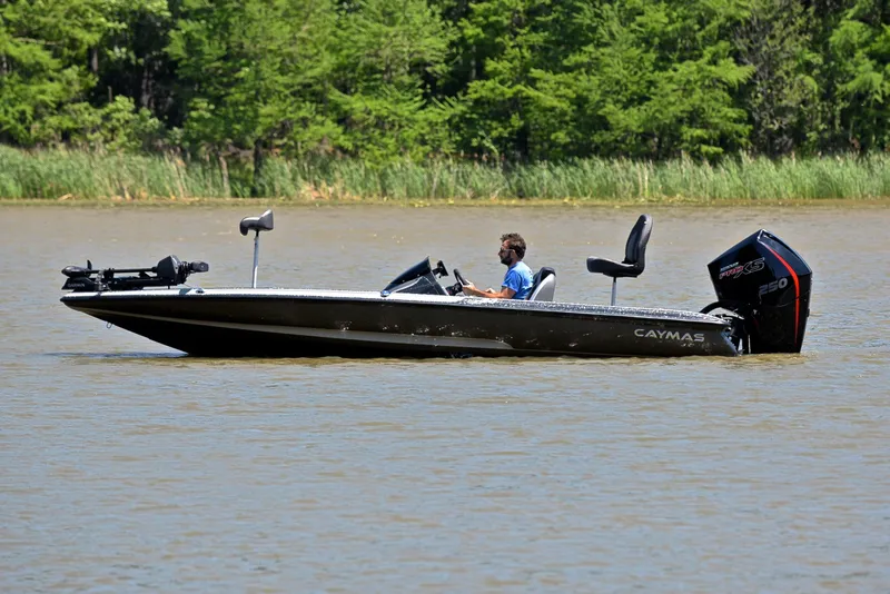 Slide: The Image of 2022 Caymas CX 20 boat on a lake with lush green background. - 8