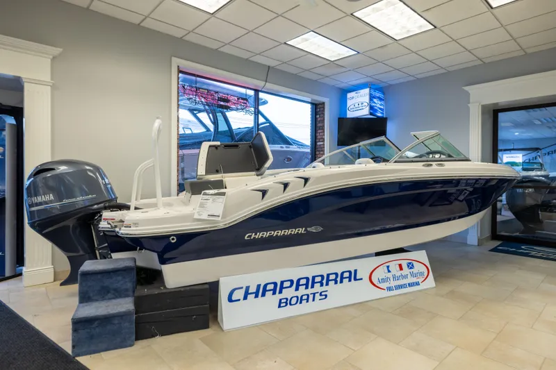 The Image of 2024 Chaparral 19 SSi OB boat displayed indoors at a dealership. - 1