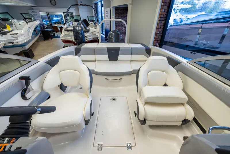 Slide: The Image of 2024 Chaparral 19 SSi OB boat interior with white seating in showroom. - 6