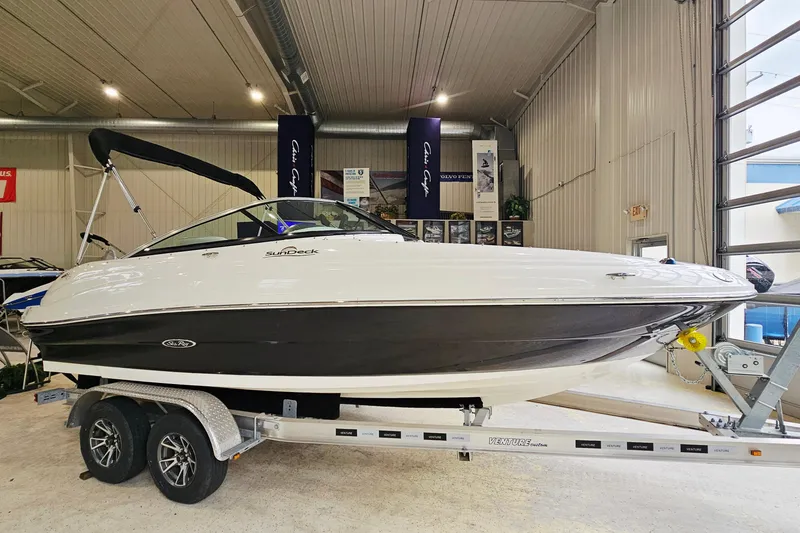 The Image of 2012 Sea Ray 200 Sundeck boat on trailer in indoor showroom. - 1