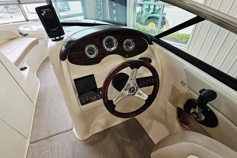 Slide: The Image of 2012 Sea Ray 200 Sundeck boat dashboard with steering wheel and control panel. - 12