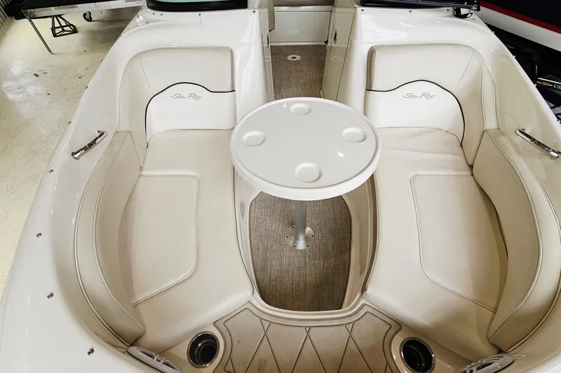 Slide: The Image of 2012 Sea Ray 200 Sundeck interior with white seating and round table. - 15