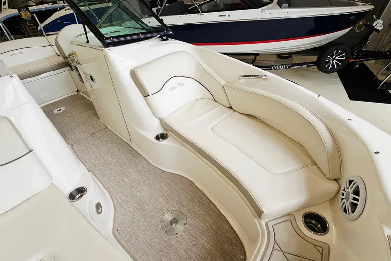 Slide: The Image of 2012 Sea Ray 200 Sundeck interior with beige seating and modern design. - 17