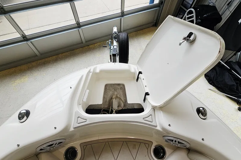 Slide: The Image of 2012 Sea Ray 200 Sundeck boat with open storage compartment in a garage. - 18