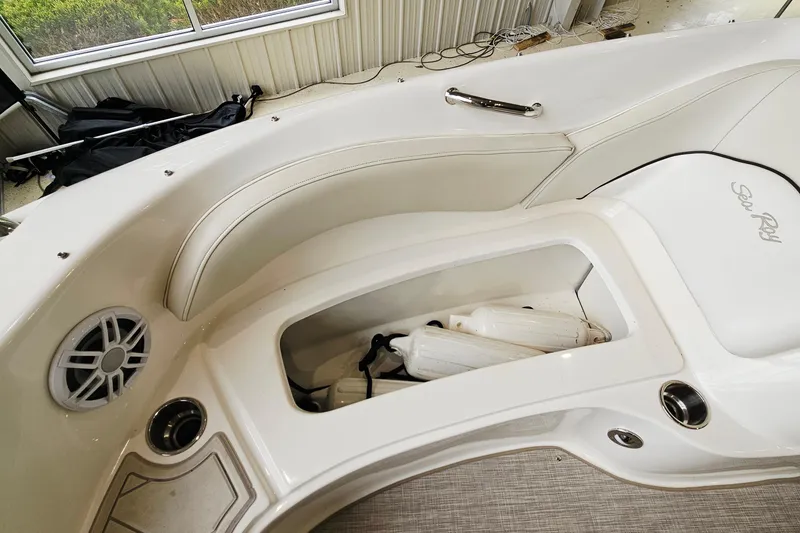 Slide: The Image of 2012 Sea Ray 200 Sundeck interior with storage compartment and speaker. - 19
