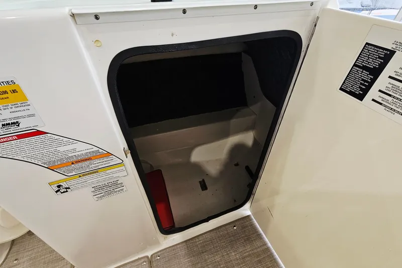 Slide: The Image of Storage compartment on a 2012 Sea Ray 200 Sundeck boat with safety labels. - 20