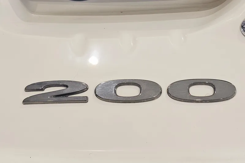 Slide: The Image of Close-up of 2012 Sea Ray 200 Sundeck emblem on white surface. - 27