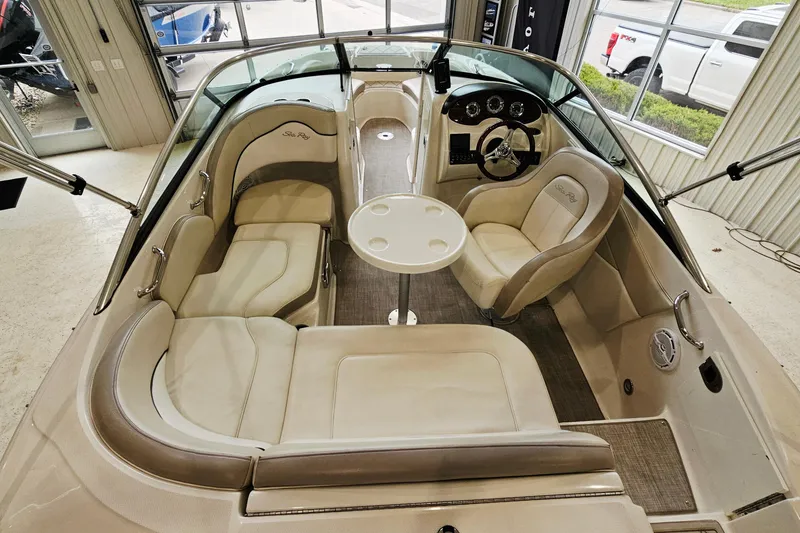 Slide: The Image of 2012 Sea Ray 200 Sundeck interior with beige seating and a central table. - 6