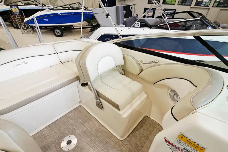 Slide: The Image of 2012 Sea Ray 200 Sundeck interior with beige seating and modern design. - 9