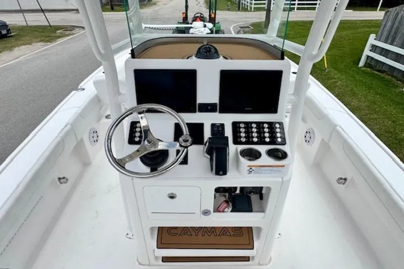 Slide: The Image of 2023 Caymas 26 HB boat dashboard with steering wheel and control panels. - 11