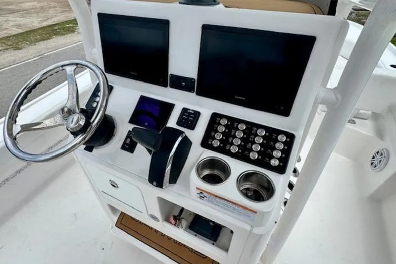 Slide: The Image of 2023 Caymas 26 HB boat dashboard with dual screens and steering wheel. - 18