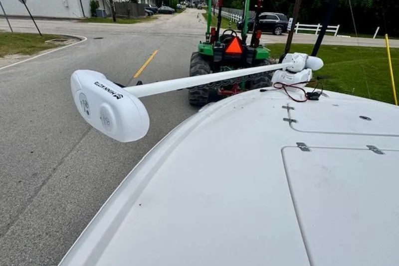 Slide: The Image of 2023 Caymas 26 HB boat with trolling motor on road, towed by a tractor. - 19