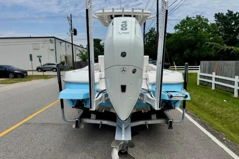 Slide: The Image of 2023 Caymas 26 HB boat with powerful outboard motor on a trailer, parked on a street. - 3
