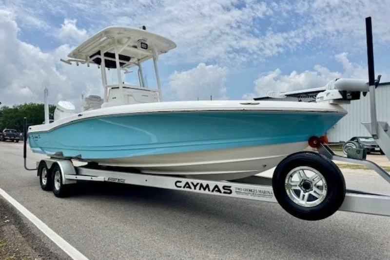 Slide: The Image of 2023 Caymas 26 HB boat on trailer, blue hull, parked on road. - 5