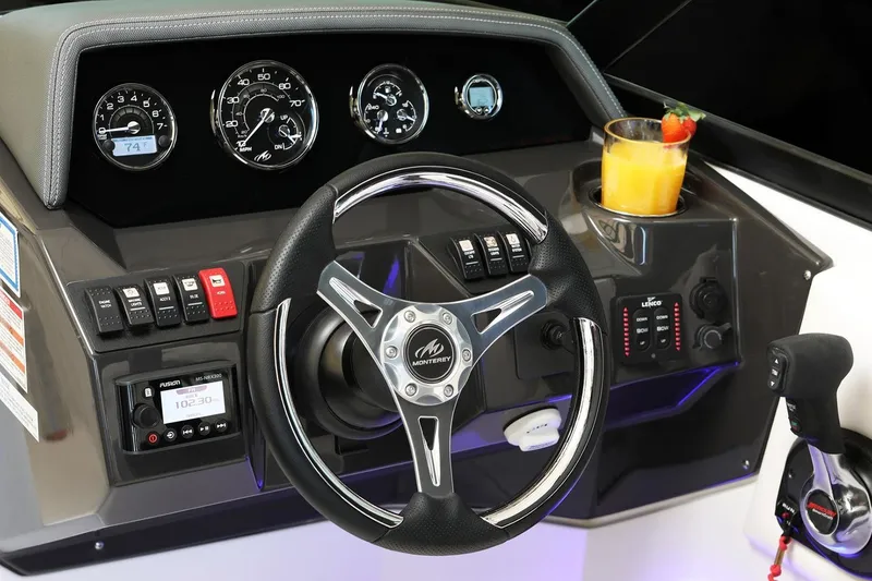 Slide: The Image of Manufacturer Provided Image: Steering wheel and dashboard of 2026 Monterey M-65 boat with gauges and a drink. - 6