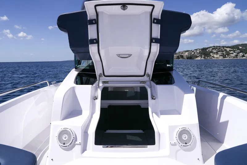 Slide: The Image of 2026 Axopar 29 XC Cross Cabin boat with open hatch, on calm sea. - 14