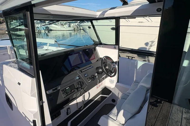 Slide: The Image of 2026 Axopar 29 XC Cross Cabin interior with modern dashboard and steering wheel. - 4