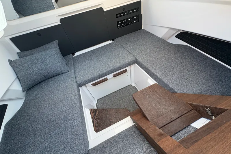 Slide: The Image of 2026 Axopar 29 XC Cross Cabin interior with gray seating and wooden accents. - 12