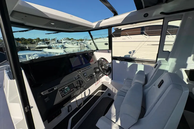 Slide: The Image of Interior view of 2026 Axopar 29 XC Cross Cabin, featuring modern dashboard and seating. - 17
