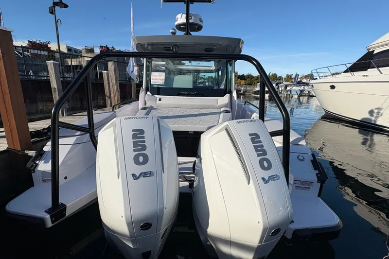 Slide: The Image of 2026 Axopar 29 XC Cross Cabin with twin Mercury 250 V8 engines docked at marina. - 2