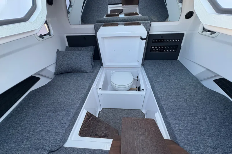Slide: The Image of 2026 Axopar 29 XC Cross Cabin interior with compact toilet and seating. - 13