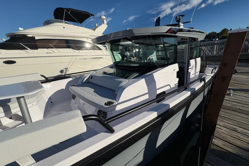 Slide: The Image of 2026 Axopar 29 XC Cross Cabin boat docked beside a larger yacht. - 6