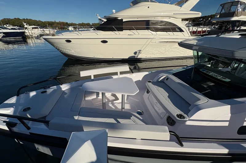 Slide: The Image of 2026 Axopar 29 XC Cross Cabin boat docked, featuring a sleek design and spacious seating area. - 5