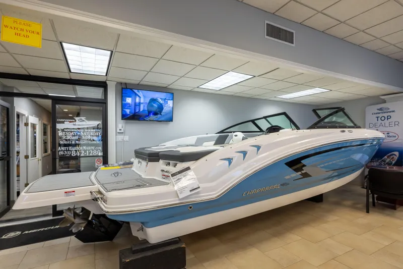 The Image of 2026 Chaparral 23 SSi boat displayed in a showroom with promotional signage. - 12
