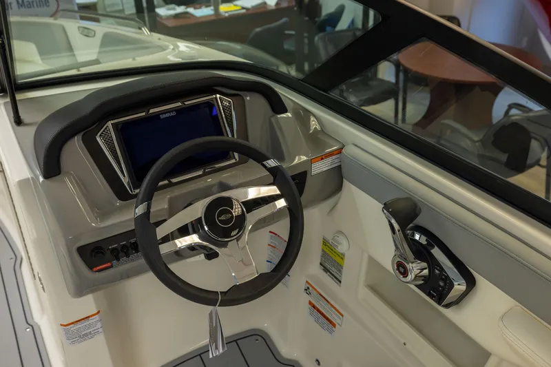 Slide: The Image of 2026 Chaparral 23 SSi boat dashboard with steering wheel and control panel. - 23