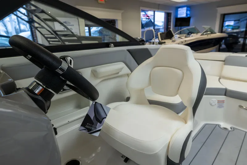 Slide: The Image of Interior view of 2026 Chaparral 23 SSi boat, featuring steering wheel and seating. - 26