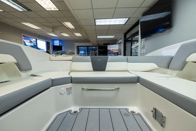 Slide: The Image of 2026 Chaparral 23 SSi boat interior with sleek seating in a showroom setting. - 27