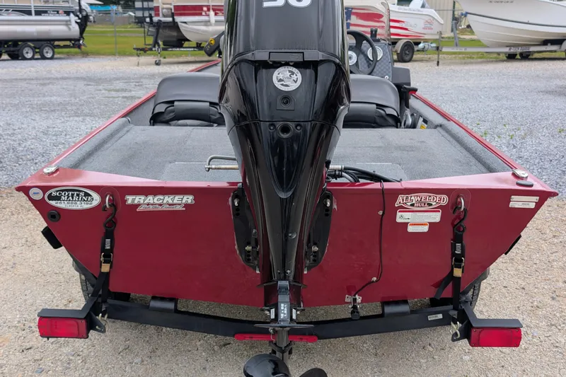 Slide: The Image of 2021 Tracker Bass Tracker Classic XL boat with motor, red exterior, parked on gravel. - 4