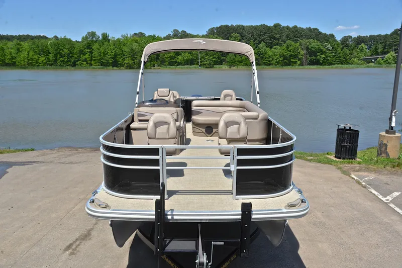 Slide: The Image of 2019 Bennington 22 pontoon boat docked by a scenic lake. - 17