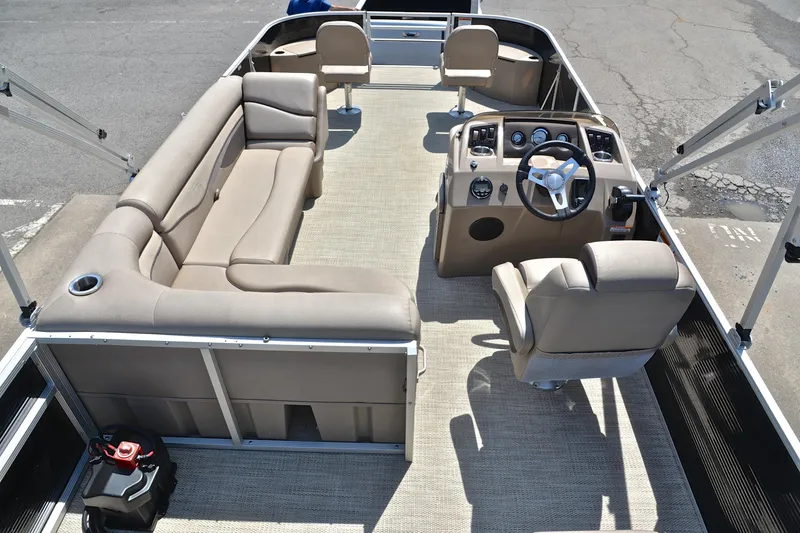 Slide: The Image of 2019 Bennington 22 pontoon boat interior with beige seating and steering console. - 18