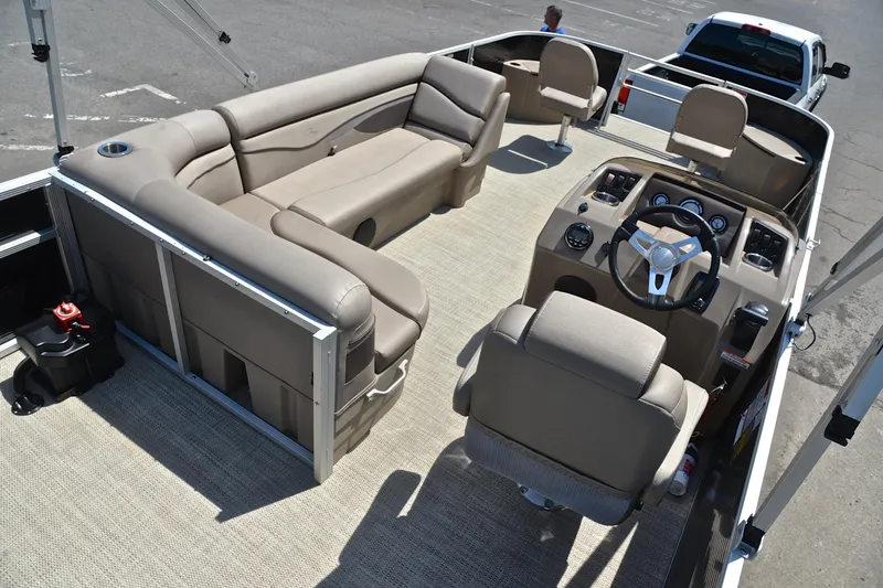 Slide: The Image of 2019 Bennington 22 pontoon boat interior with beige seating and steering console. - 19
