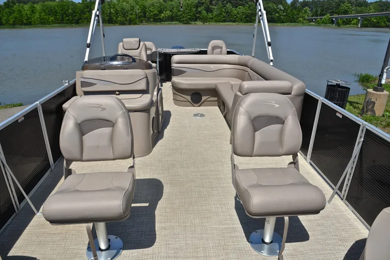Slide: The Image of 2019 Bennington 22 pontoon boat interior with plush seating on a serene lake. - 20