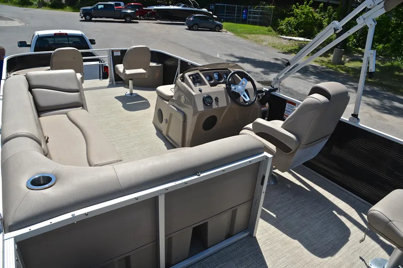 Slide: The Image of 2019 Bennington 22 pontoon boat interior with beige seating and steering console. - 25
