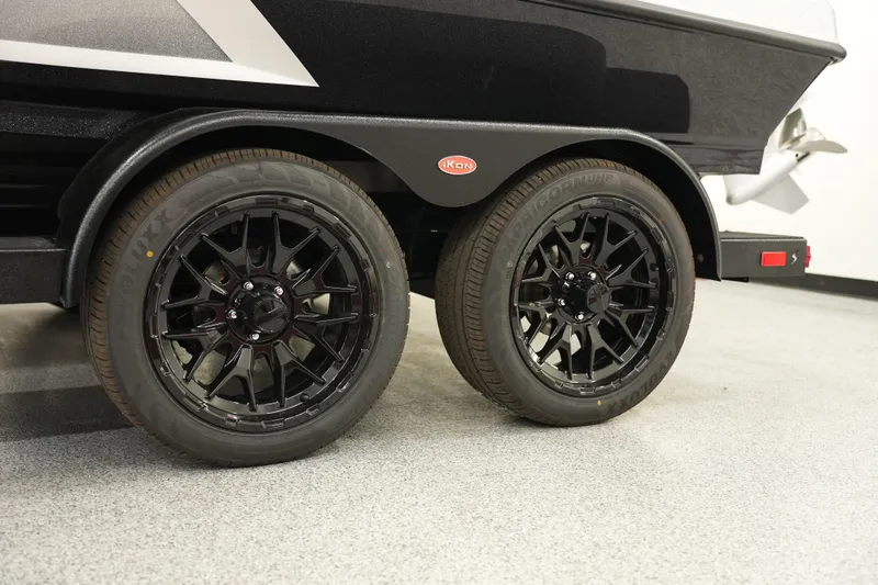 Slide: The Image of 2026 iKon LXE20 trailer with black alloy wheels on a showroom floor. - 4