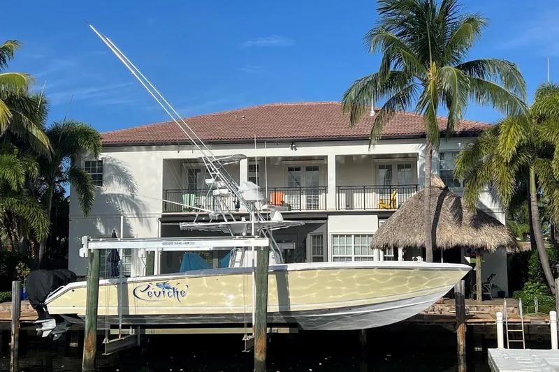 The Image of 2010 Venture 39 Open boat docked near a tropical waterfront home with palm trees. - 0