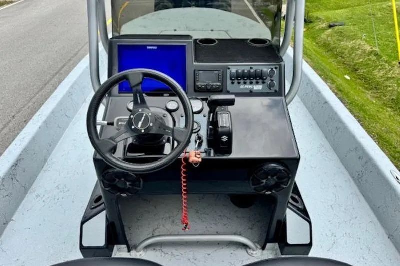 Slide: The Image of 2023 El Pescador 24 CAT boat dashboard with steering wheel and electronic controls. - 10