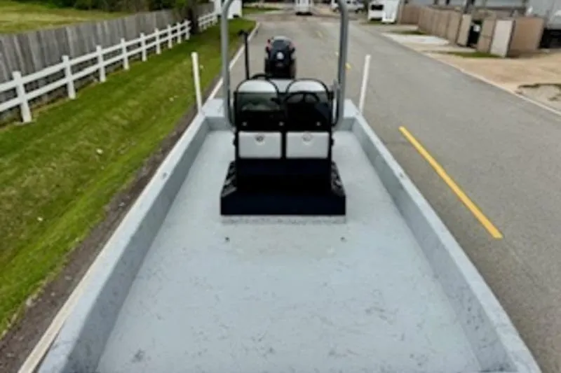 Slide: The Image of 2023 El Pescador 24 CAT boat on trailer, parked on a suburban street. - 13
