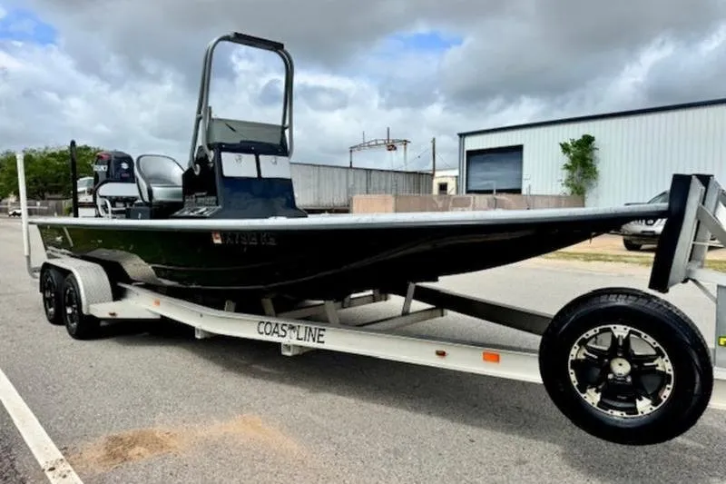 Slide: The Image of 2023 El Pescador 24 CAT boat on trailer, parked outdoors under cloudy sky. - 5