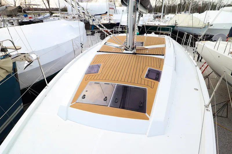 Slide: The Image of 2026 Hanse 360 sailboat deck with wood finish, docked among other boats. - 10