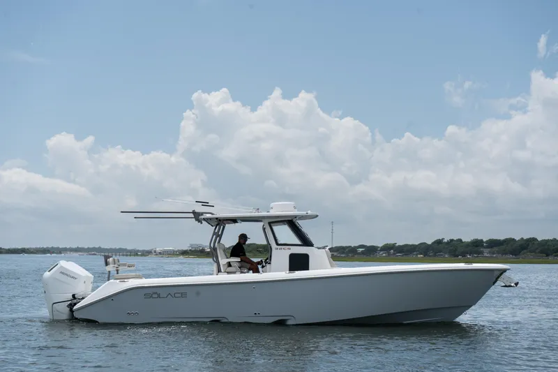 The Image of 2026 Solace 32CS boat cruising on a calm waterway under a partly cloudy sky. - 1