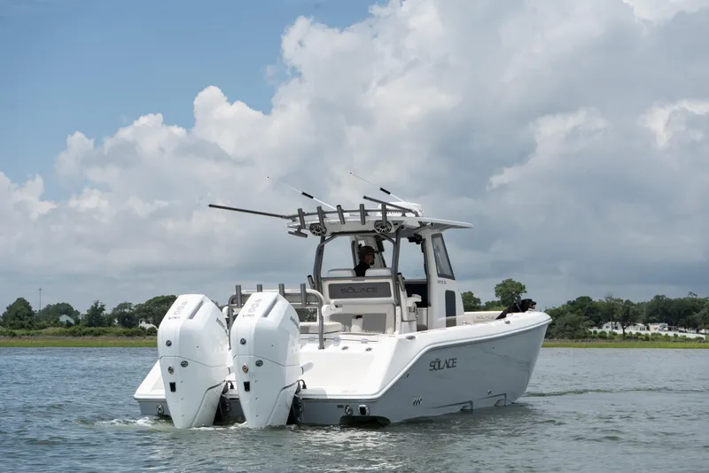 Slide: The Image of 2026 Solace 32CS boat cruising on a calm lake under a cloudy sky. - 3