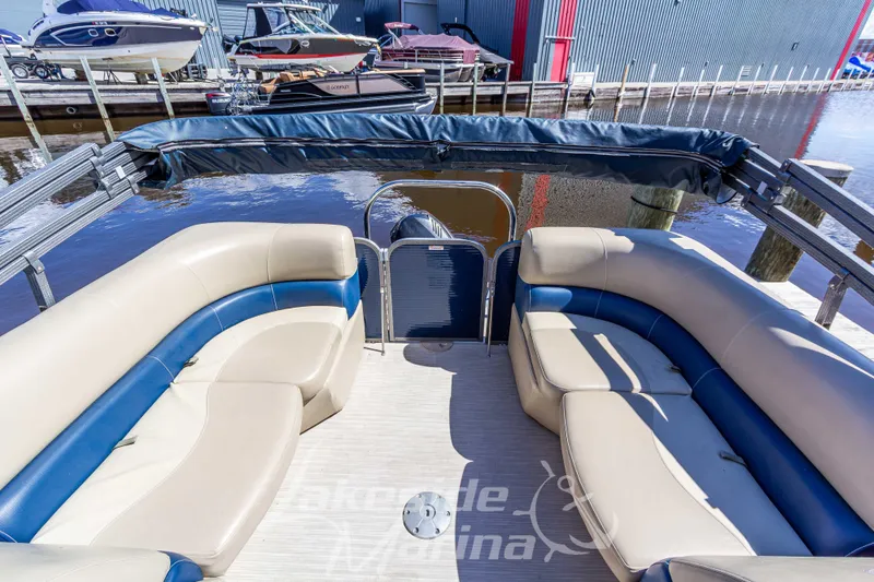 Slide: The Image of 2018 Manitou Aurora 23 LE RF VP pontoon boat with spacious seating at a marina dock. - 17