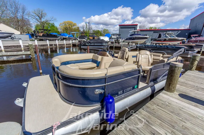 Slide: The Image of 2018 Manitou Aurora 23 LE RF VP pontoon boat docked at a marina under a blue sky. - 4