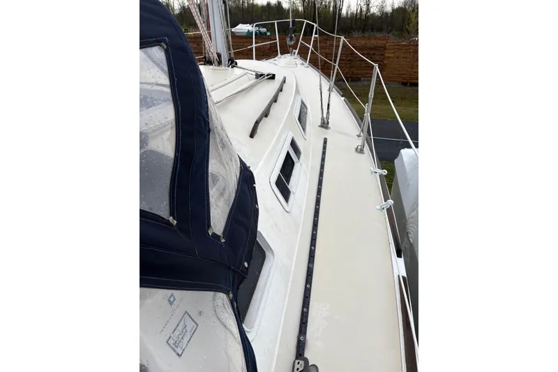Slide: The Image of 1988 Pearson 28 sailboat deck with blue canvas cover and railing. - 10