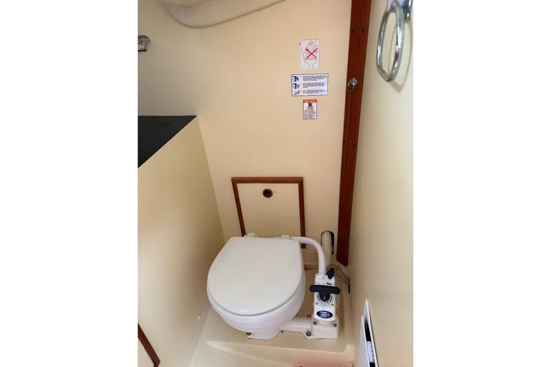 Slide: The Image of Wooden interior of a 1988 Pearson 28 sailboat, featuring a compartment with a handle. - 39