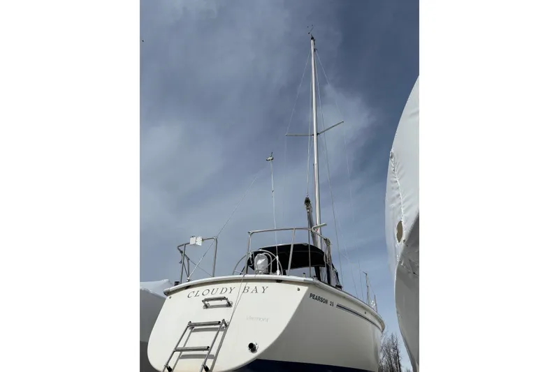 Slide: The Image of 1988 Pearson 28 sailboat "Cloudy Bay" with mast against a cloudy sky. - 5
